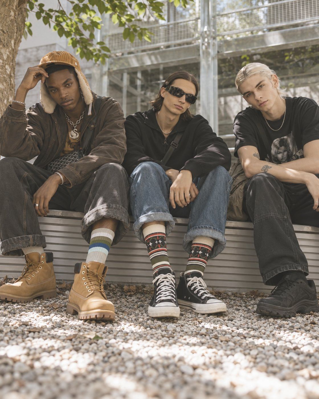 Three friends in a courtyard wearing TAKIA striped and fair isle crew socks